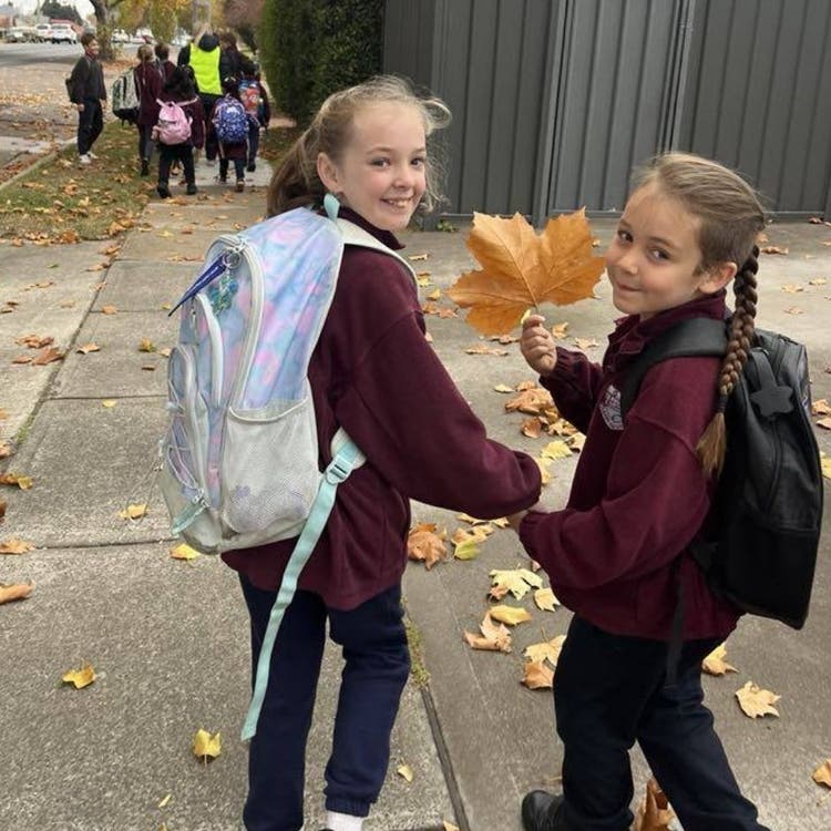 Two students holding hands walking