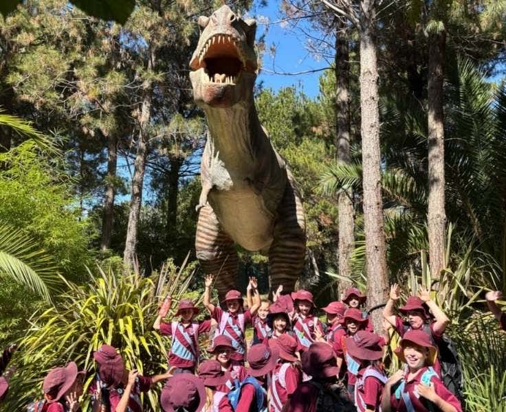 Students on an excursion in front of a dinosaur